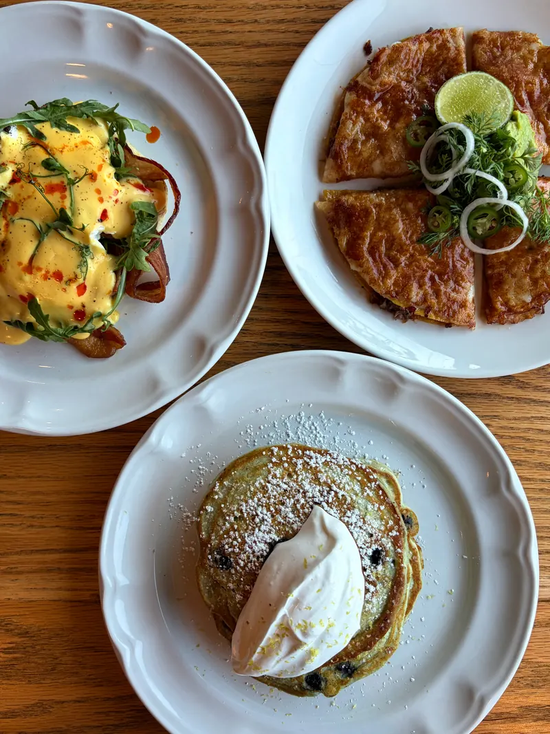 Brunch en Merci: huevos benedictinos, queso birria y blueberry pancakes con crema batida