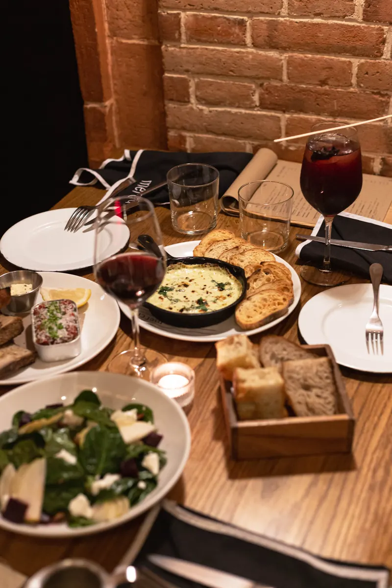 Cena en Merci: platos para compartir, pan artesanal y vino tinto a la luz de las velas